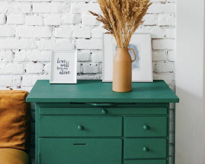 A set of drawers with a plant on top